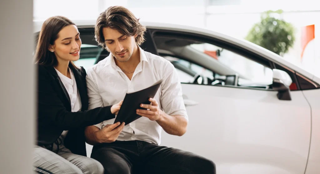 man and woman choosing a car in showroom